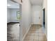 Inviting hallway featuring tile flooring, leading to a bright living space with modern gray wood-look flooring at 412 Ranch Trl, Casselberry, FL 32707