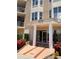 Inviting building entrance with a modern design, complemented by vibrant red flowers at 4628 Harbour Village Blvd # 2308, Ponce Inlet, FL 32127