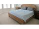 Tranquil bedroom with a wicker bed frame, soft blue bedding, and natural light at 4628 Harbour Village Blvd # 2308, Ponce Inlet, FL 32127