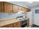 Functional kitchen with light wood cabinets, laminate countertops, and essential appliances at 4870 S Semoran Blvd # 1904, Orlando, FL 32822