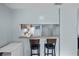 Kitchen view looking through the bar counter; featuring white appliances, and dark bar stools at 4870 S Semoran Blvd # 1904, Orlando, FL 32822