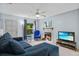 Cozy living room features a comfortable blue sectional sofa, a fireplace, a ceiling fan, and a large window at 4870 S Semoran Blvd # 1904, Orlando, FL 32822