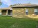 Back of the home showing the covered patio area and simple landscaping at 4871 Fells Cove Ave, Kissimmee, FL 34744