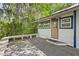 Cozy back porch with a seating area, wood floors, and plenty of shade from the trees at 516 Tybee Pl, Orlando, FL 32829