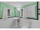 This bathroom has mint green walls and white tile with black and green accent tiles at 516 Tybee Pl, Orlando, FL 32829