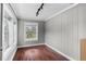 A bright space with dark hardwood floors, a modern track light fixture, and a view of the outdoors at 516 Tybee Pl, Orlando, FL 32829