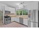 Bright kitchen featuring stainless steel appliances, white cabinetry, and butcher block countertops at 516 Tybee Pl, Orlando, FL 32829
