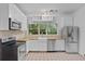 Bright kitchen featuring stainless steel appliances, white cabinetry, and butcher block countertops at 516 Tybee Pl, Orlando, FL 32829