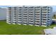 Exterior view of a condominium building with private balconies overlooking green space at 5201 S Atlantic Ave # 703A, New Smyrna Beach, FL 32169
