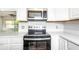 Kitchen with stainless steel microwave, oven and white cabinets at 5300 Locksley Ave, Orlando, FL 32810