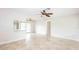 Bright, neutral living room boasts tile floors, a ceiling fan, and open access to the kitchen at 5300 Locksley Ave, Orlando, FL 32810