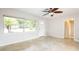 Bright, neutral living room boasts large windows, tile floors, and a ceiling fan at 5300 Locksley Ave, Orlando, FL 32810