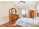Spacious bedroom with wood floors and a large dresser with a three-paneled mirror at 5308 Pinebury Ct, Orlando, FL 32808