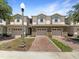 Charming townhouses with brick driveways and attached garages under a beautiful blue sky at 576 Prospect Pt, Oviedo, FL 32765
