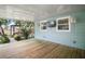 Inviting back porch with wood flooring, white ceiling, outdoor TV, ceiling fans, and backyard access at 716 N Rockingham Ave, Tavares, FL 32778