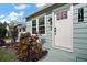 Inviting front entrance with white door, modern house numbers, and vibrant landscaping at 716 N Rockingham Ave, Tavares, FL 32778