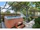 Relaxing hot tub under pergola lights, complimented by a wooden step for easy access at 716 N Rockingham Ave, Tavares, FL 32778