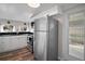 Bright kitchen with stainless steel refrigerator, white cabinets, and granite countertops at 716 N Rockingham Ave, Tavares, FL 32778