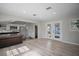 Open floor plan with light wood floors connecting the dining area to the updated kitchen at 716 N Rockingham Ave, Tavares, FL 32778