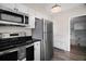Stainless steel appliances and white cabinets in a brightly lit updated kitchen at 716 N Rockingham Ave, Tavares, FL 32778