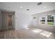 Bright living room featuring hardwood floors, a shiplap accent wall, and ample natural light at 716 N Rockingham Ave, Tavares, FL 32778