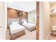 Stylish bedroom with twin beds, wood accent wall, and view of natural light with comfortable decor at 7478 Brooklyn Dr, Kissimmee, FL 34747