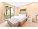 Bright bedroom with a king bed, neutral tones, an outdoor view, and a tufted bench at 7478 Brooklyn Dr, Kissimmee, FL 34747