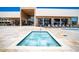 Luxurious community pool and spa area surrounded by a travertine deck with lounge seating at 7478 Brooklyn Dr, Kissimmee, FL 34747