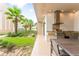 Beautiful outdoor kitchen with a grill, counter space, and a dining area overlooking lush landscaping at 7478 Brooklyn Dr, Kissimmee, FL 34747