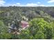 An aerial view of a cozy home nestled amongst mature trees with a glimpse of the city skyline in the distance at 809 Sugar House Blvd, Port Orange, FL 32129