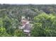An aerial view of a cozy home nestled amongst mature trees with lush landscape and a serene, neighborhood street at 809 Sugar House Blvd, Port Orange, FL 32129