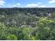 An aerial view of a vibrant green canopy of trees surrounding a cozy neighborhood street with buildings in the skyline at 809 Sugar House Blvd, Port Orange, FL 32129