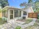 A home's cozy backyard with a patio, screened enclosure, and wooden fence under a clear, blue sky at 809 Sugar House Blvd, Port Orange, FL 32129