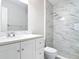 Bathroom with a marble tiled shower, white vanity, and modern fixtures at 809 Sugar House Blvd, Port Orange, FL 32129