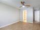 Bedroom boasts ensuite bathroom access, with a ceiling fan and wood-look flooring at 809 Sugar House Blvd, Port Orange, FL 32129