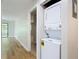 Bright hallway with hardwood floors and a stacked washer and dryer at 809 Sugar House Blvd, Port Orange, FL 32129