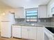 Bright kitchen boasts white cabinets, granite counters, stainless steel appliances, and a window over the sink at 809 Sugar House Blvd, Port Orange, FL 32129