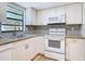 Kitchen features white cabinets, granite countertops, stainless steel sink, and neutral tile backsplash at 809 Sugar House Blvd, Port Orange, FL 32129