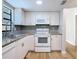 Updated kitchen features white cabinets, granite countertops, stainless steel sink, and subway tile backsplash at 809 Sugar House Blvd, Port Orange, FL 32129