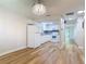 An open-concept kitchen with modern lighting, white cabinets, stainless steel appliances, and wood-look flooring at 809 Sugar House Blvd, Port Orange, FL 32129