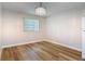 This light-filled living room offers wood-look floors, a modern light fixture, and neutral wall color at 809 Sugar House Blvd, Port Orange, FL 32129