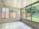 Enclosed porch with tile flooring offering access to the backyard through a glass paneled door at 809 Sugar House Blvd, Port Orange, FL 32129