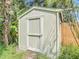 Exterior shot of a storage shed in the backyard surrounded by overgrown vegetation at 809 Sugar House Blvd, Port Orange, FL 32129
