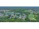 Aerial view of a community featuring homes with screened pools amidst lush greenery and a golf course at 875 Bentley Green Cir, Winter Springs, FL 32708