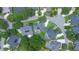 Aerial view showcasing a home with a screened pool surrounded by verdant landscaping in a neighborhood setting at 875 Bentley Green Cir, Winter Springs, FL 32708