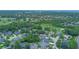 An aerial view showcases a community with homes and a golf course interwoven among mature trees at 875 Bentley Green Cir, Winter Springs, FL 32708