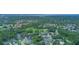 An aerial view captures a residential community with a golf course, nestled among green trees and waterways at 875 Bentley Green Cir, Winter Springs, FL 32708