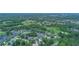 An aerial view shows a residential community surrounded by lush greenery and a golf course at 875 Bentley Green Cir, Winter Springs, FL 32708