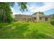 Lush backyard with screened-in patio, mature trees, and a well-maintained lawn at 875 Bentley Green Cir, Winter Springs, FL 32708