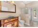 Charming bathroom with a wood vanity, stone countertop, and walk-in shower at 875 Bentley Green Cir, Winter Springs, FL 32708